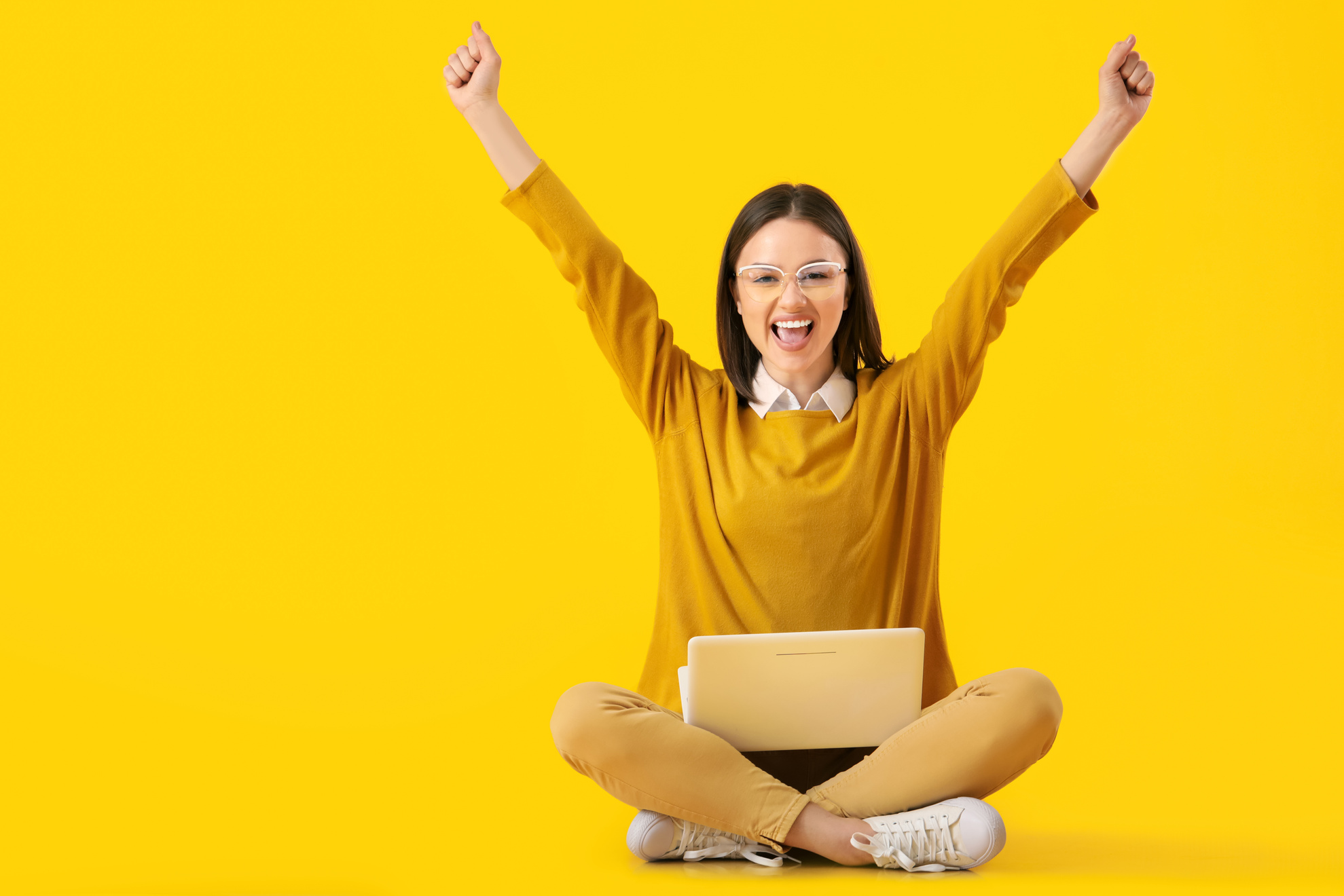 Happy Young Woman with Laptop on Yellow Background