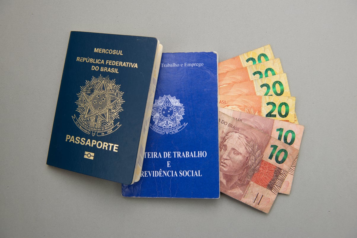 Brazilian work card (carteira de trabalho), passport and money. TRANSLATE: "Federative Republic of Brazil, Ministry of Labor. Work record booklet and Social Welfare."